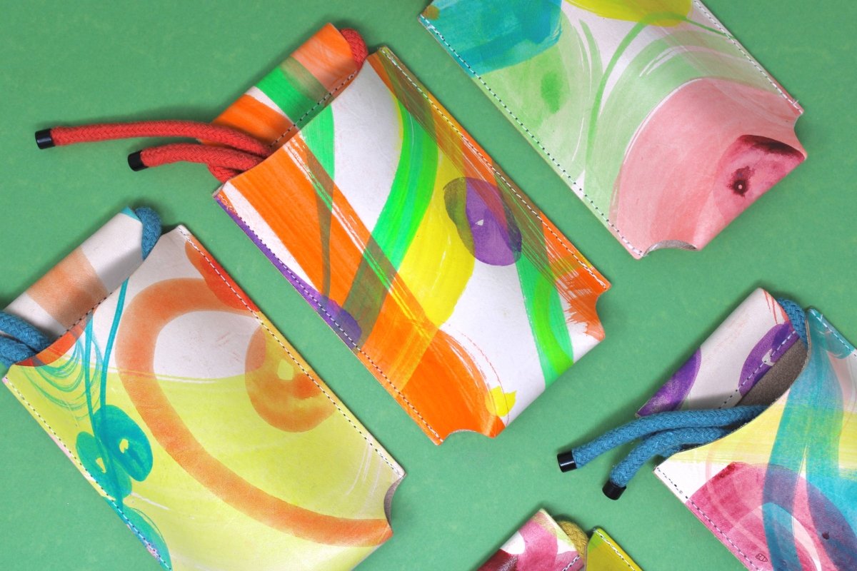 Hand-painted leather phone bag by Ark Colour Design featuring a colorful, artistic design and compact, stylish silhouette.