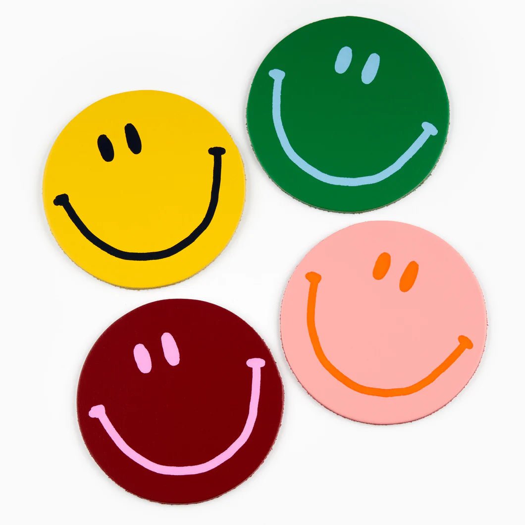 Set of four leather coasters featuring cheerful happy face smiley designs by Ark Colour Design