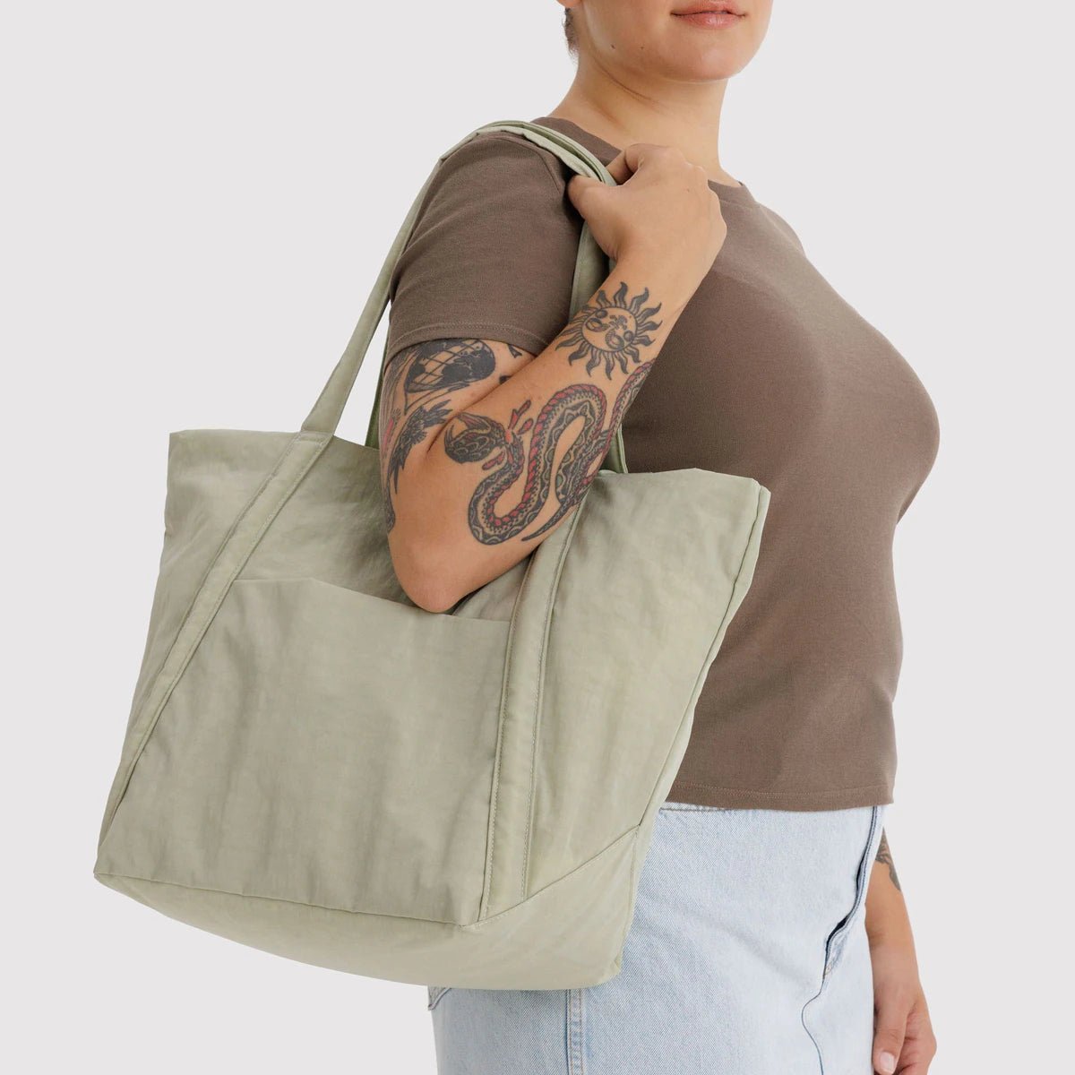Person holding a celadon tote bag against a plain background