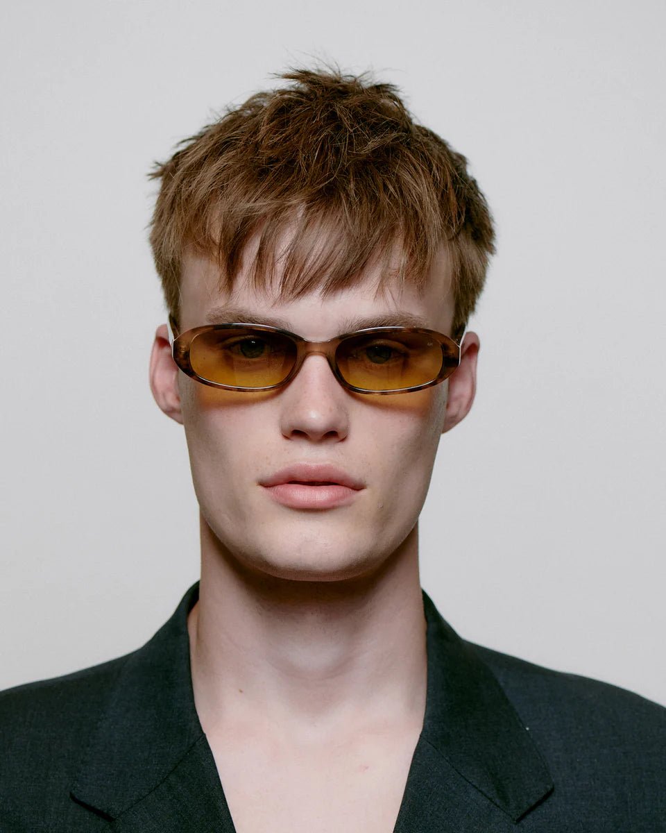 A. Kjaerbede Macy sunglasses with round frames and tinted lenses, stylishly displayed on a white background.