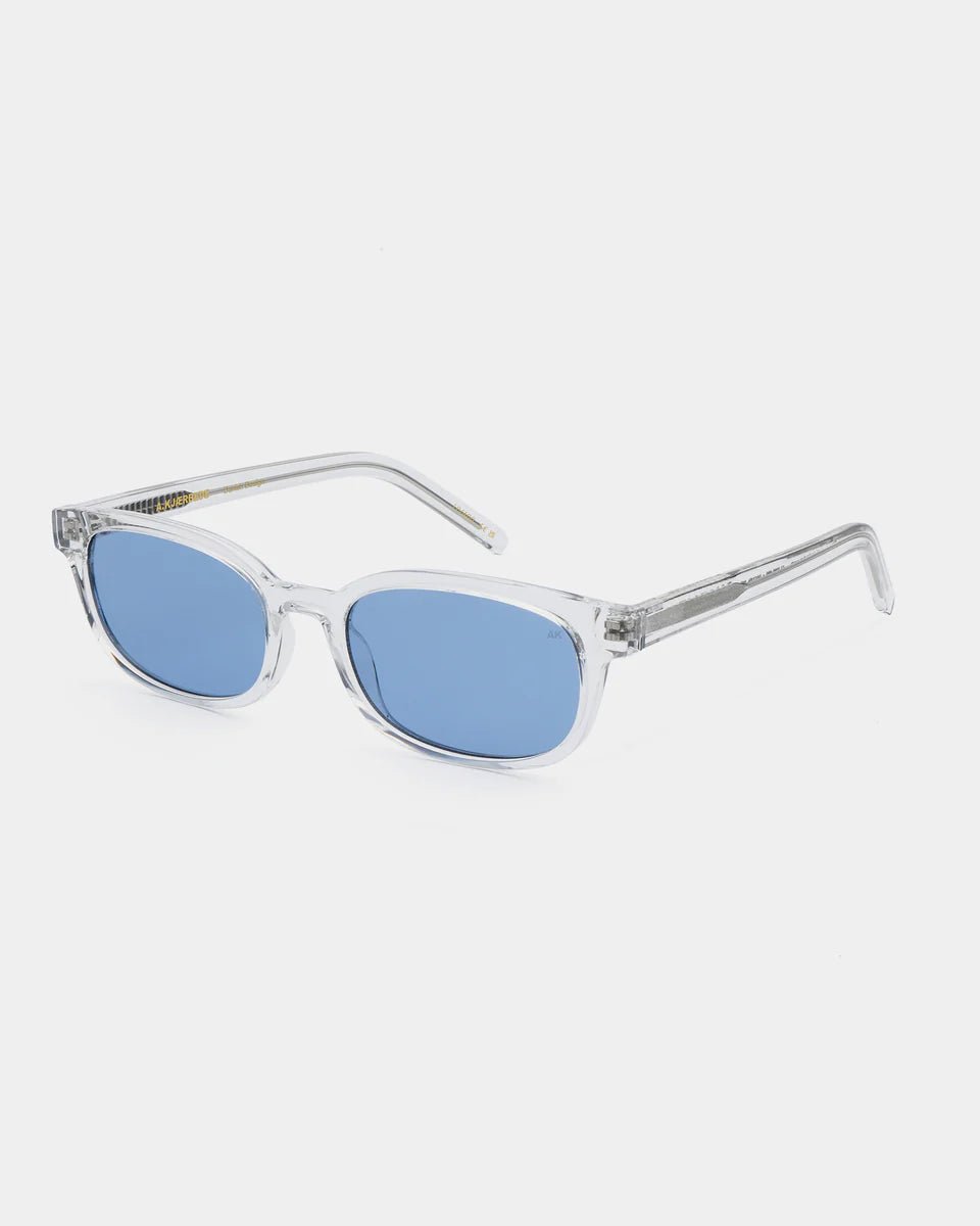 A. Kjaerbede Charlie sunglasses with clear, crystal frames and tinted lenses, stylishly displayed on a white background.