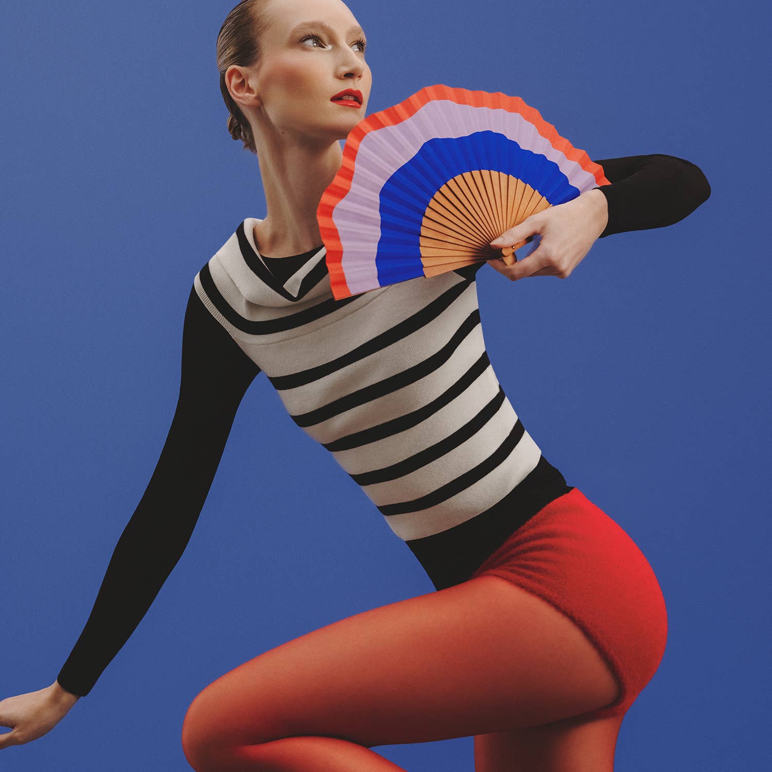 A A FAN OF Fluid Shapes MIDI fan in blue, lilac, and orange with 23 cm diameter, showcasing its colorful, modern design.