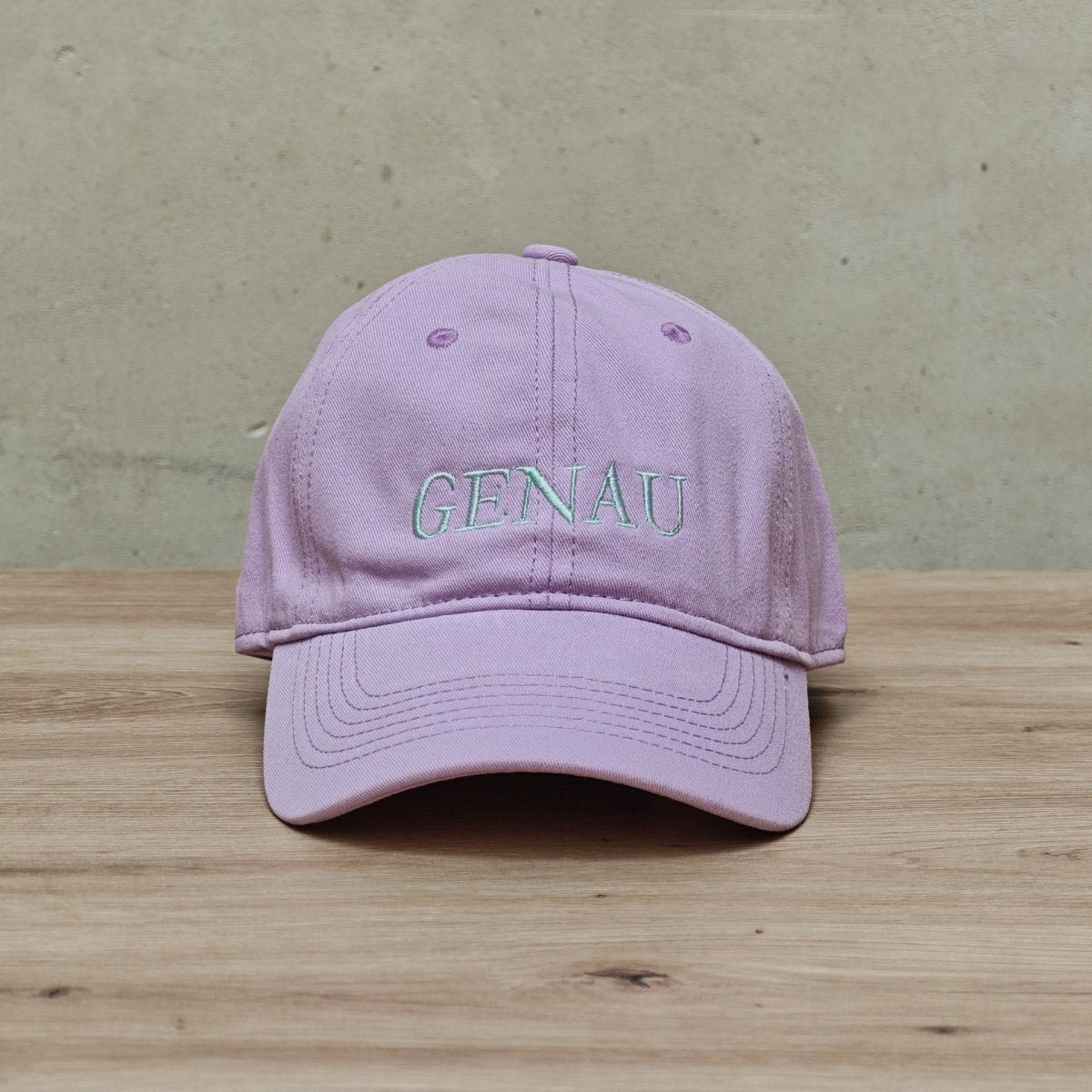 Embroidered 'GENAU' cap by Hallesches Haus featuring a stylish fabric cap with detailed embroidery on the front.