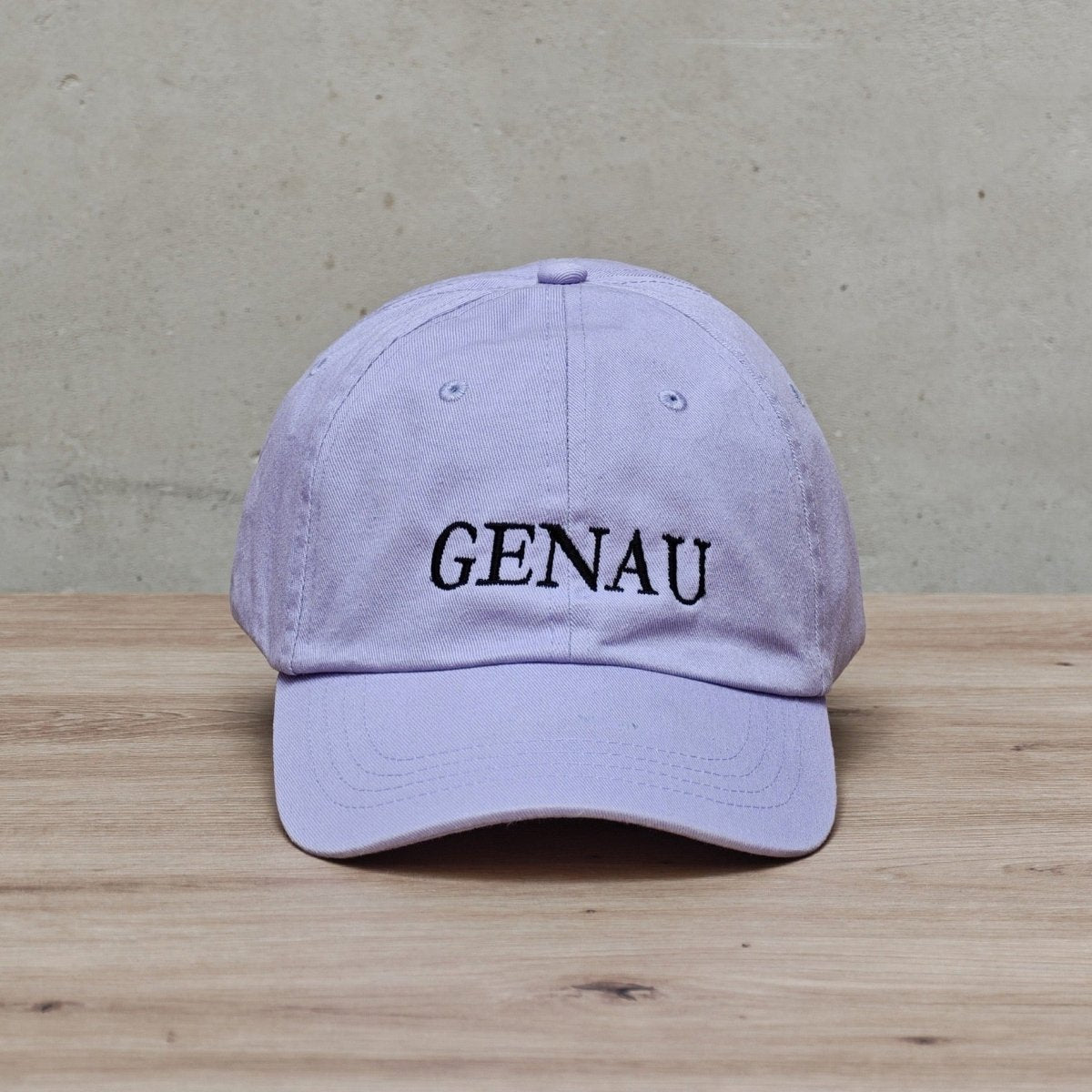 Embroidered 'GENAU' cap by Hallesches Haus featuring a classic design with detailed stitching on the front panel.