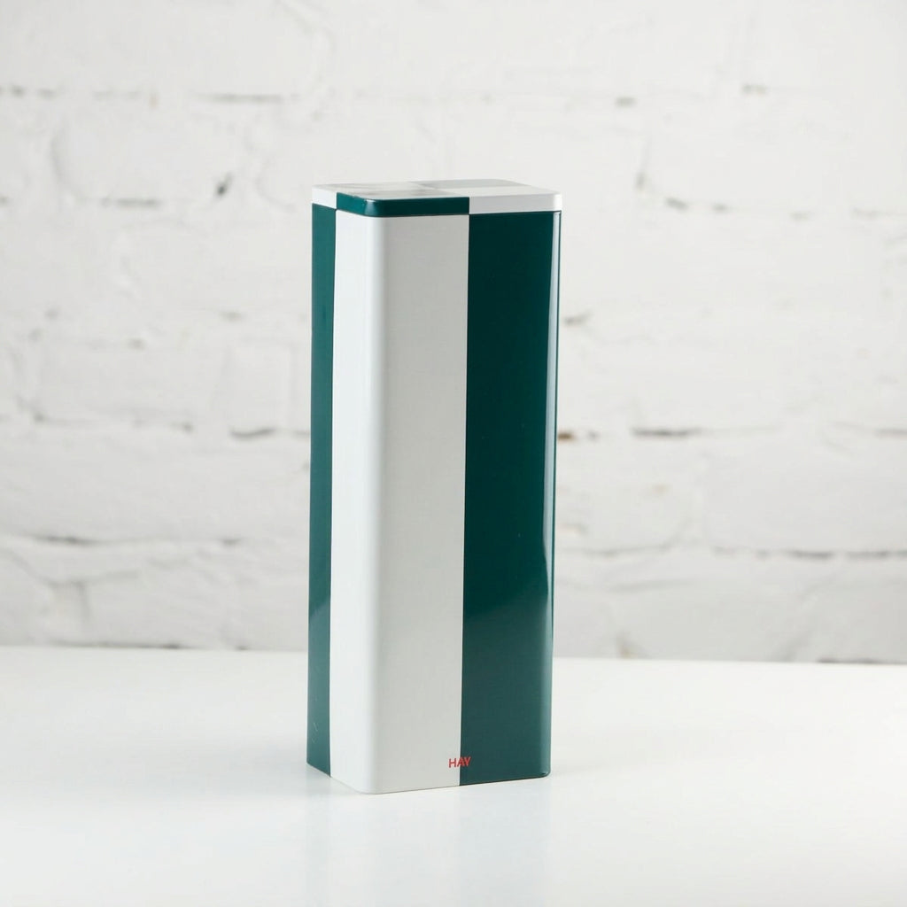 HAY tin container for storage and organization, with a sleek cylindrical design in a modern, minimalist style.