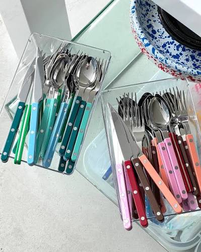 Sabre Bistrot Style cutlery set featuring stainless steel forks, knives, and spoons arranged on a table for dining.
