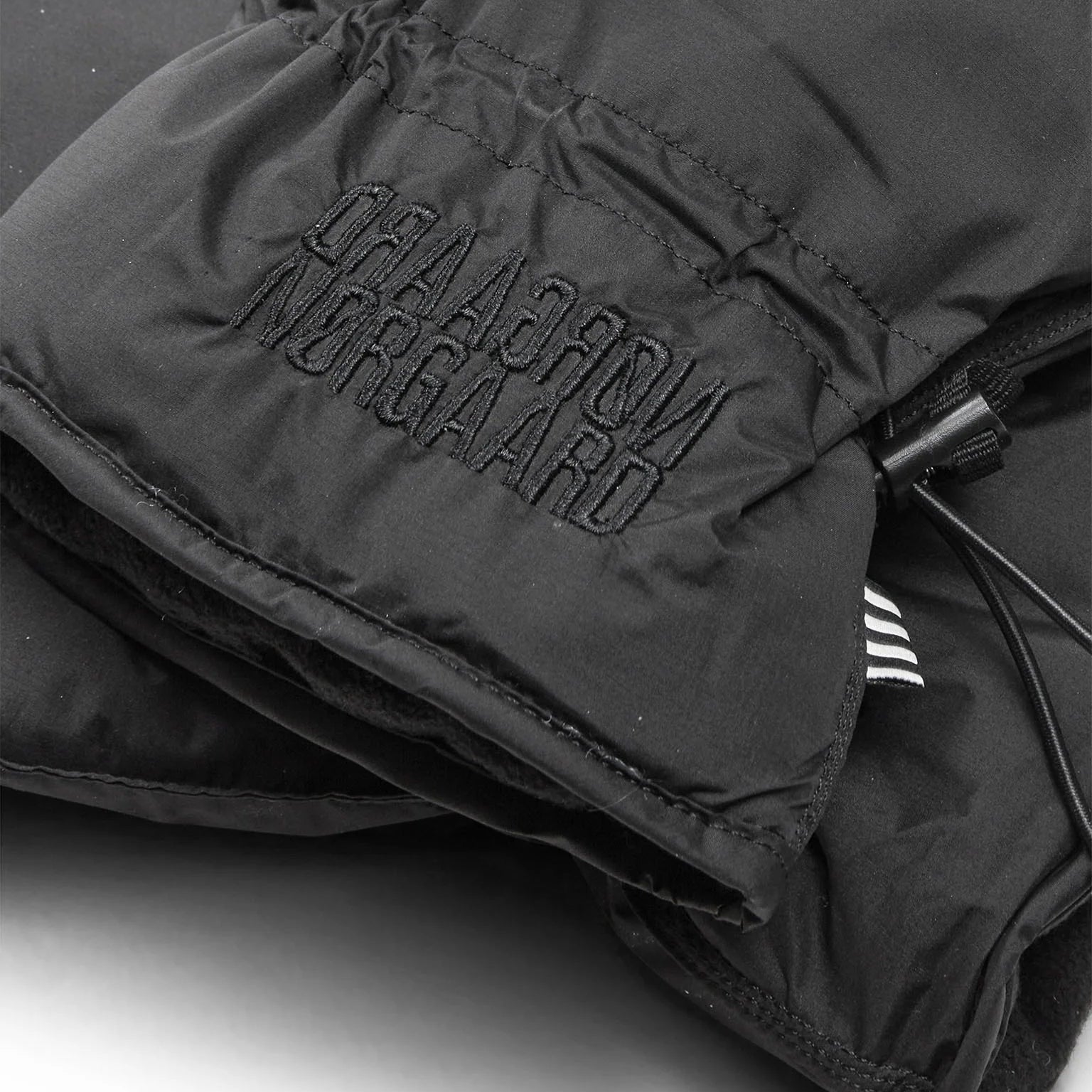 Black gloves with 'Norgaard' branding on a white background