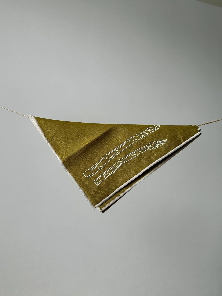 Set of two MÆGEN linen blend napkins in asparagus green with elegant, natural fabric texture for dining or table decor.