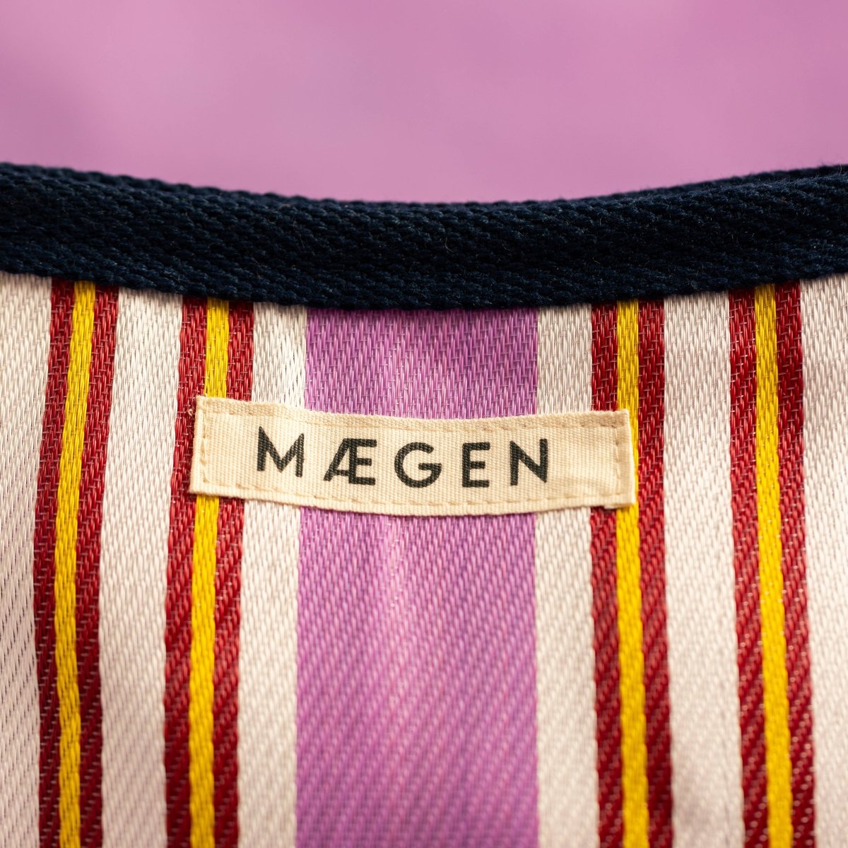 Navy, pink, and red MÆGEN pouch with zipper closure, compact design and vibrant color blocks.