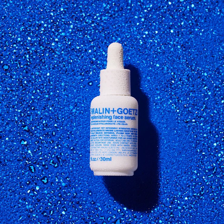 Malin+Goetz Replenishing Face Serum in a clear glass bottle with dropper for skincare hydration and rejuvenation.