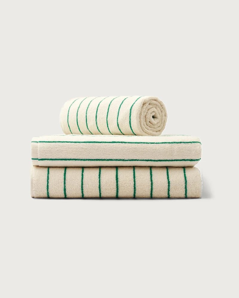 Stack of Bongusta Naram towels in pure white and grass green, soft and plush bathroom towels displayed folded.