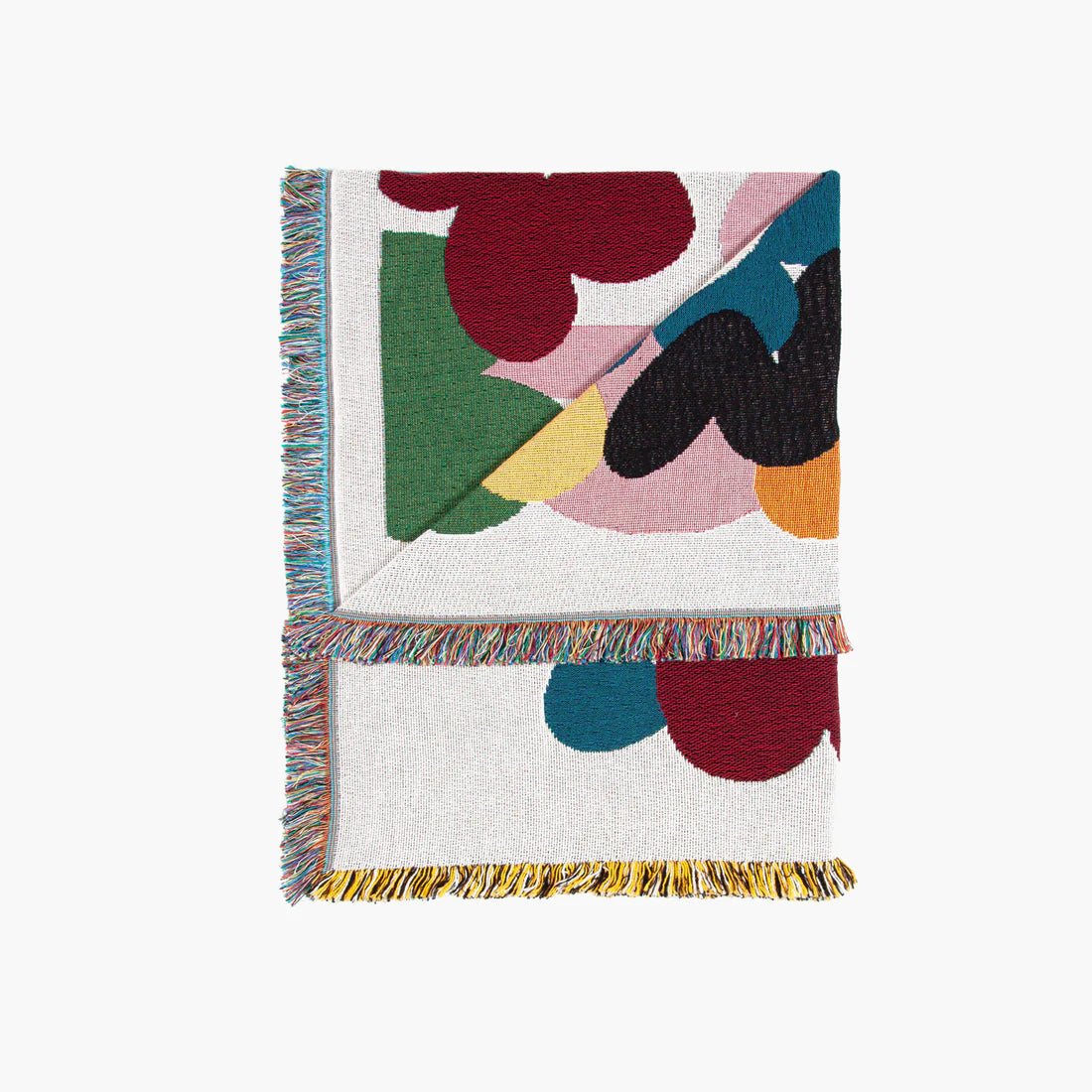 Folded colorful abstract patterned blanket on a white background