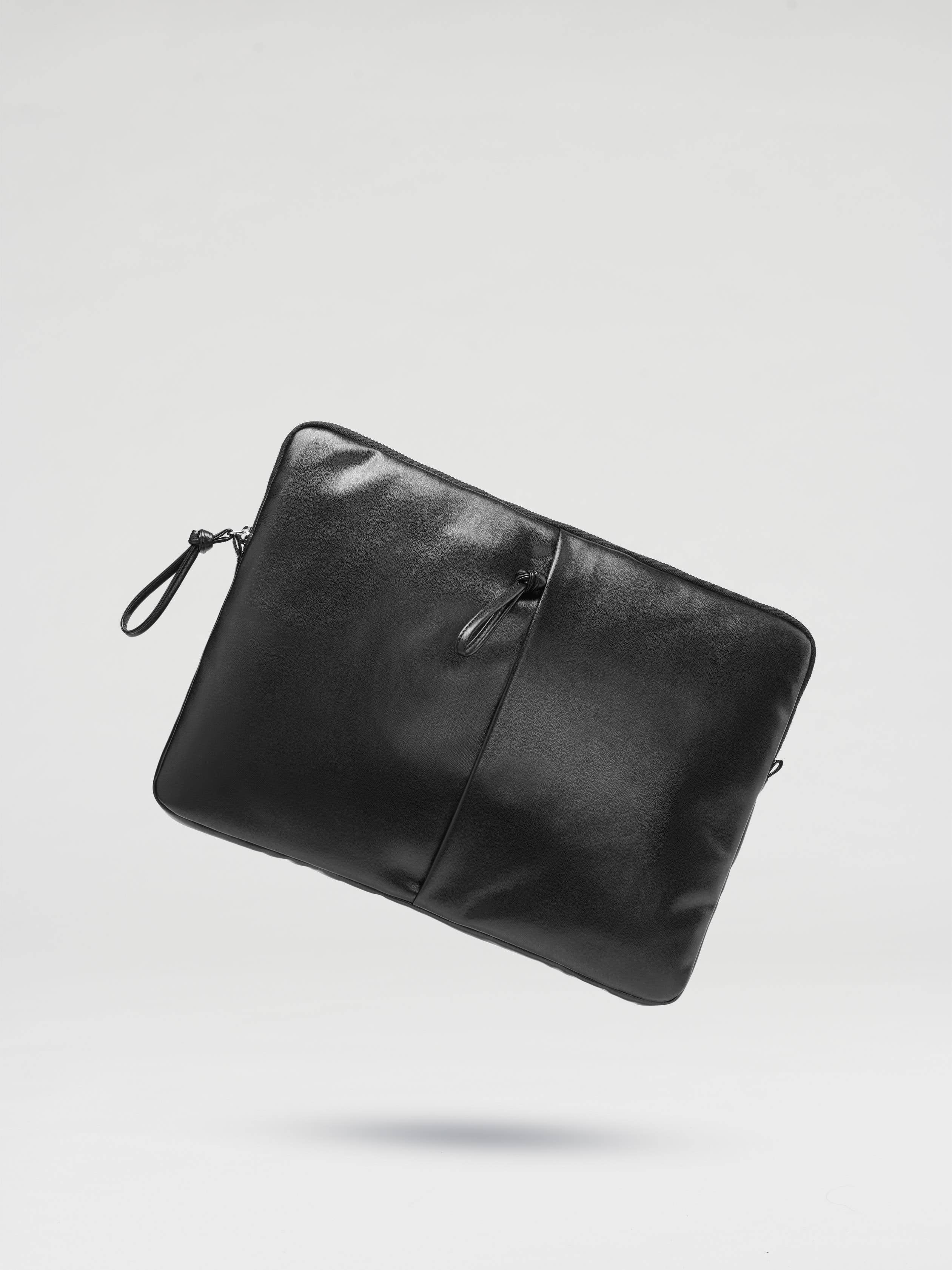 Black padded laptop sleeve for 13 and 14-inch laptops from Ölend Backpacks, shown with a sleek, protective interior.