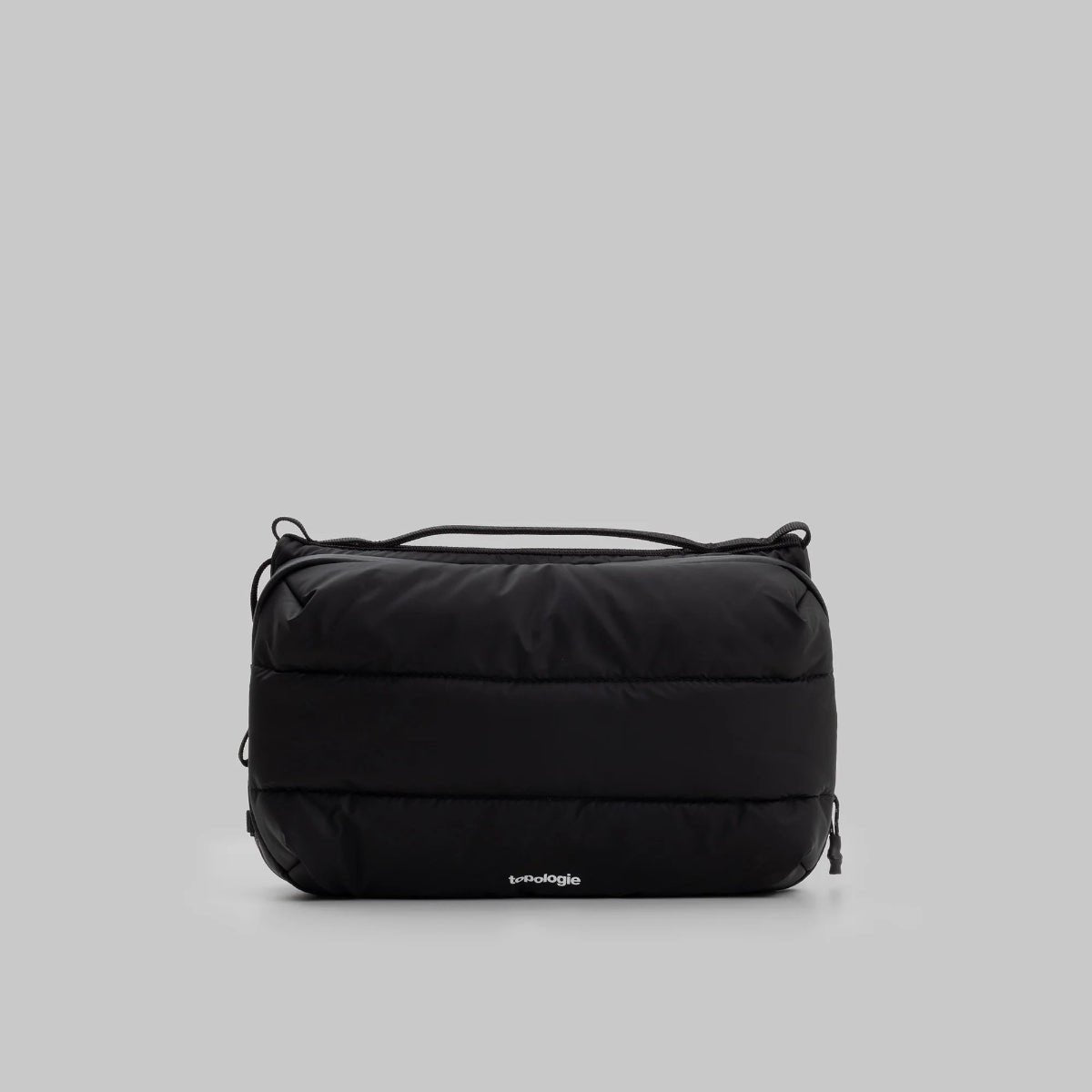 large puffy black bottle bag from Topologie on a grey background
