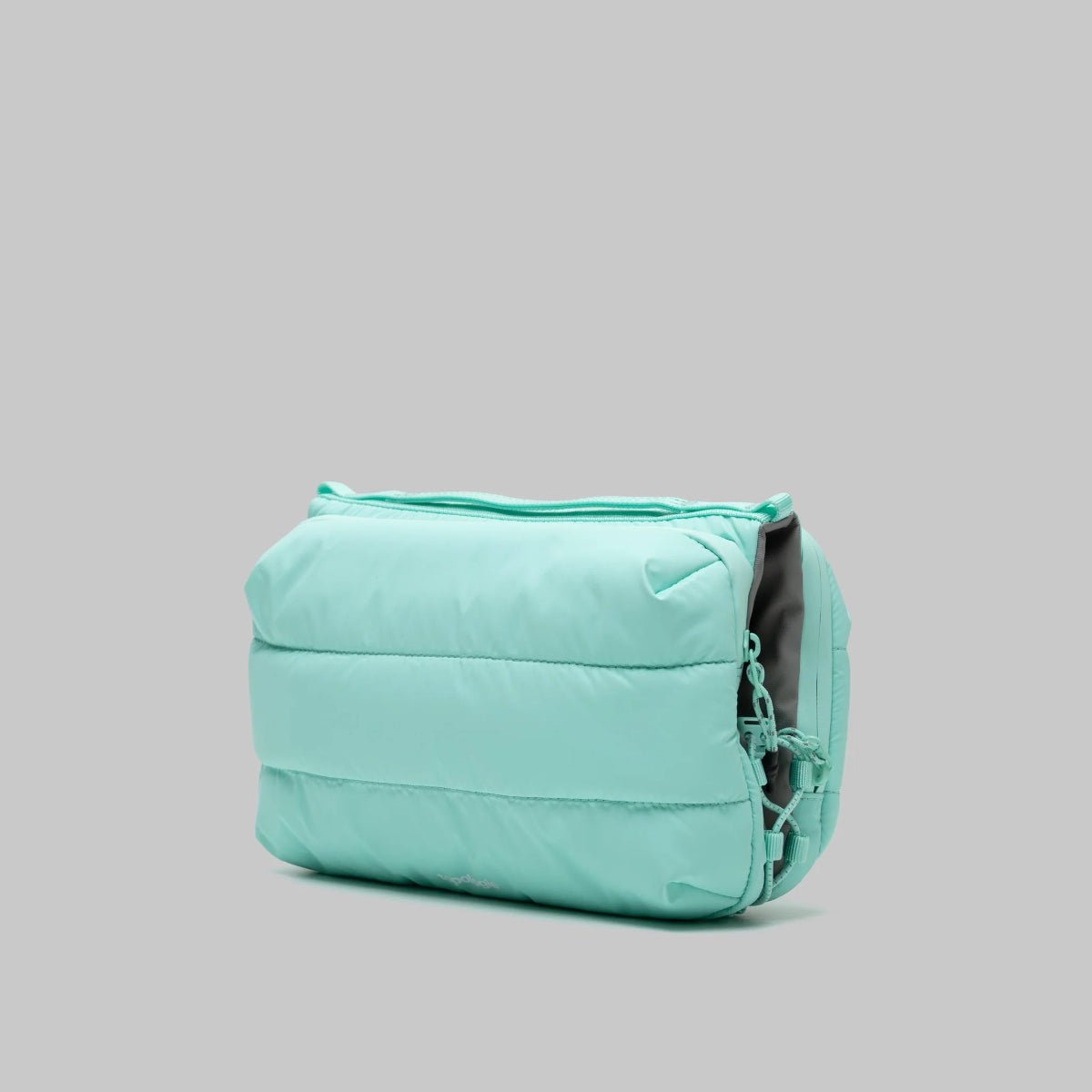 Large puffy mint green bottle bag from topologie bag on a gray background