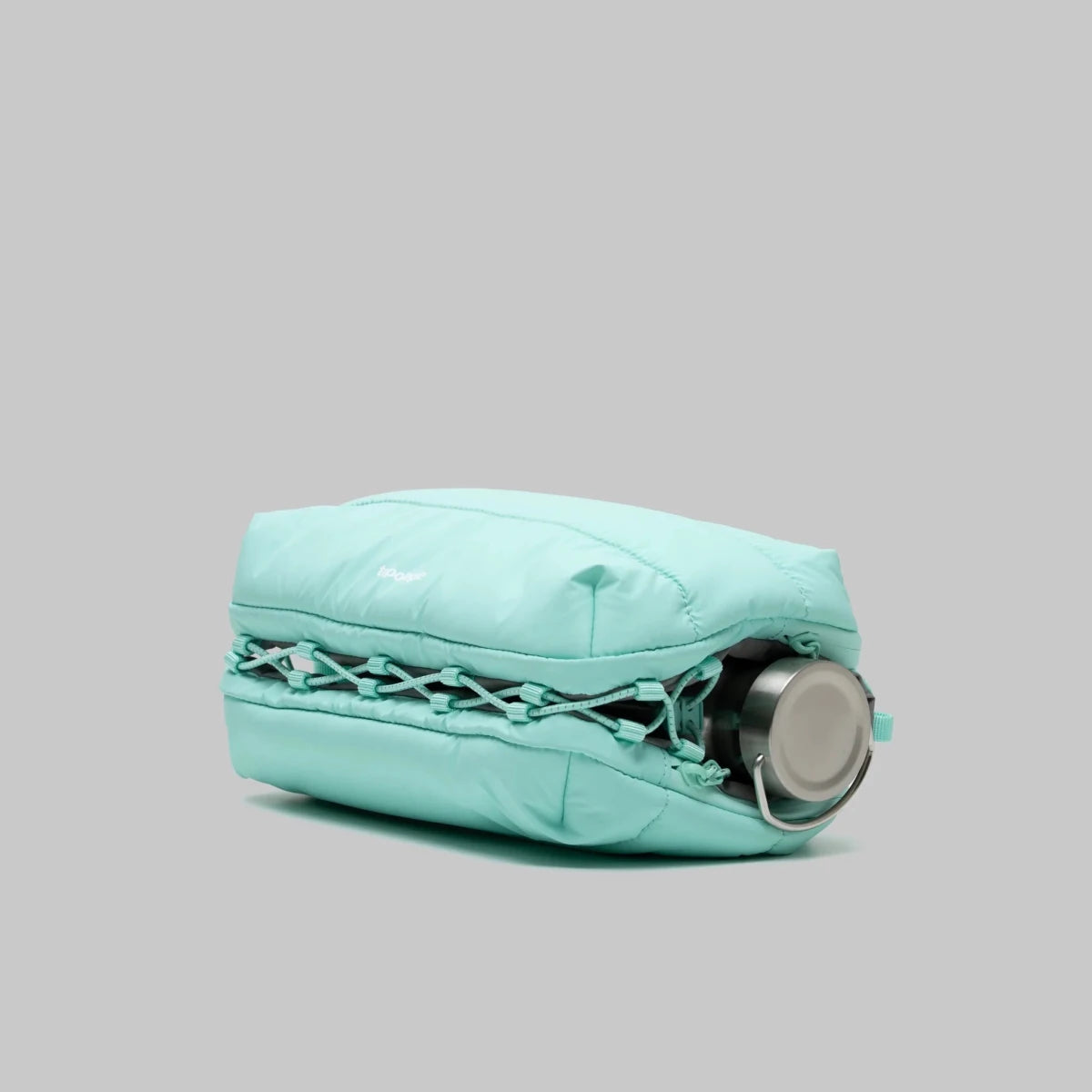 Large puffy mint green bottle bag from topologie bag on a gray background