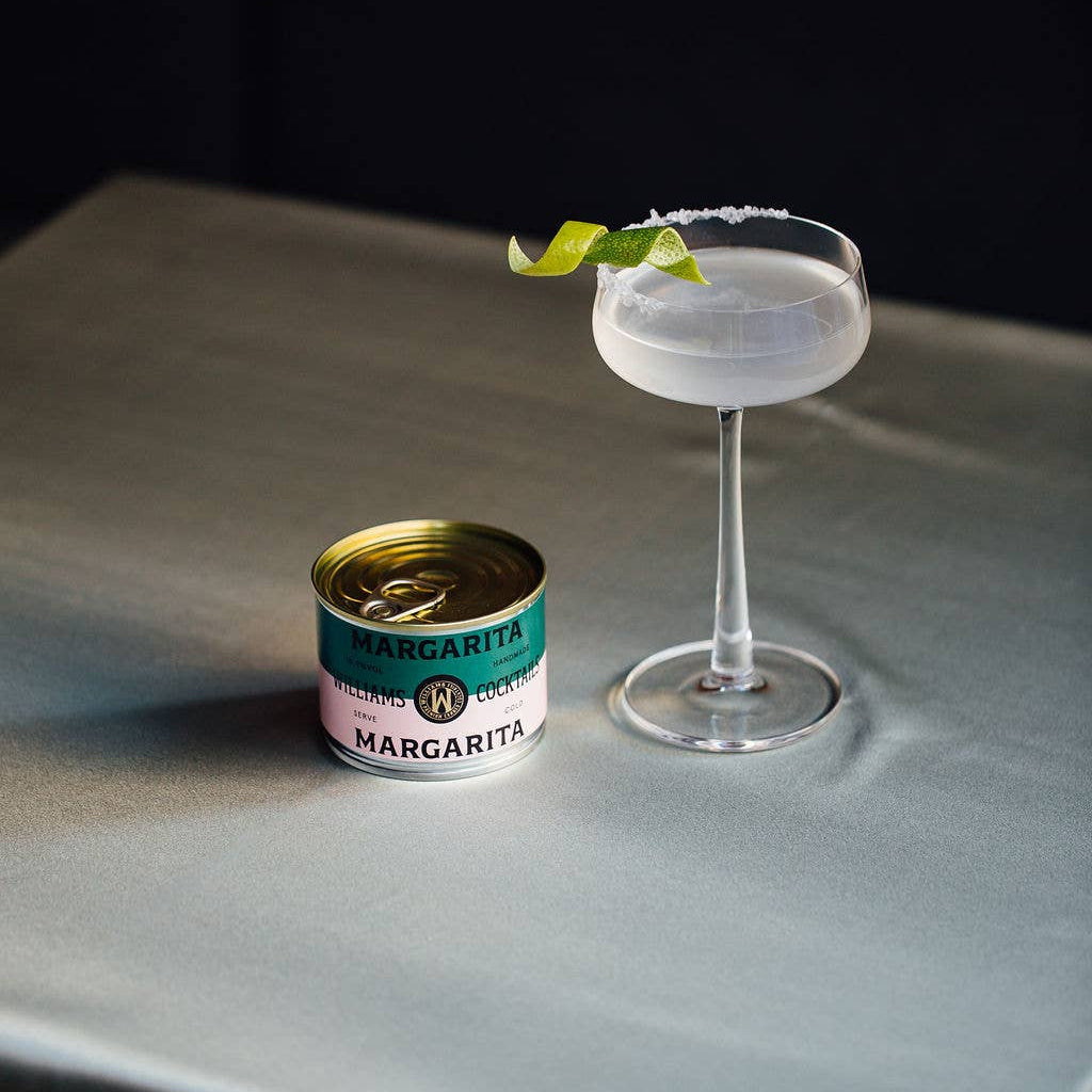 Williams Premium Canned Cocktails Margarita cocktail in a clear can, garnished with lime wedge and salt rim, ready to serve.