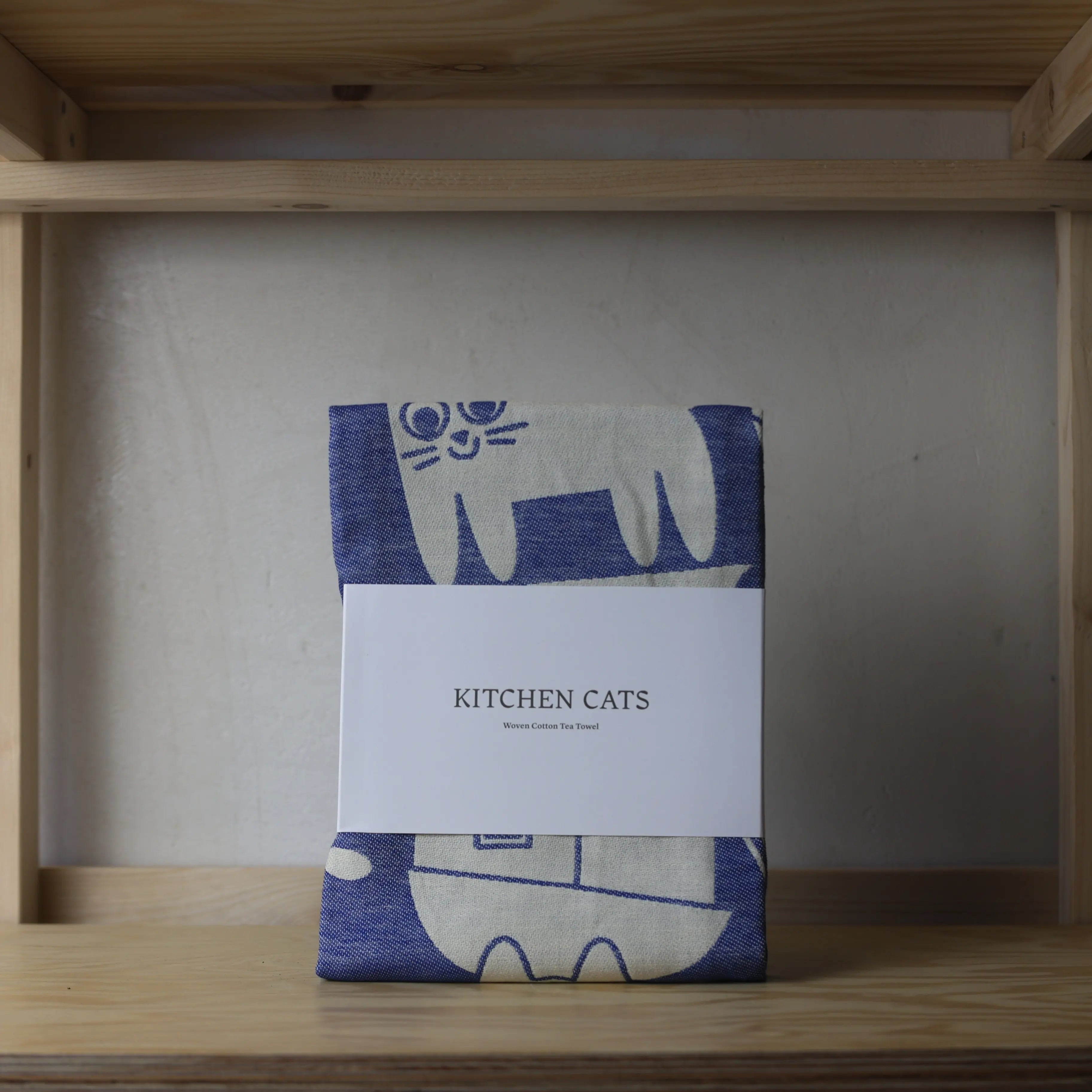 Wrap Magazine Kitchen Cats tea towel featuring colorful cat illustrations on fabric perfect for kitchen decor.
