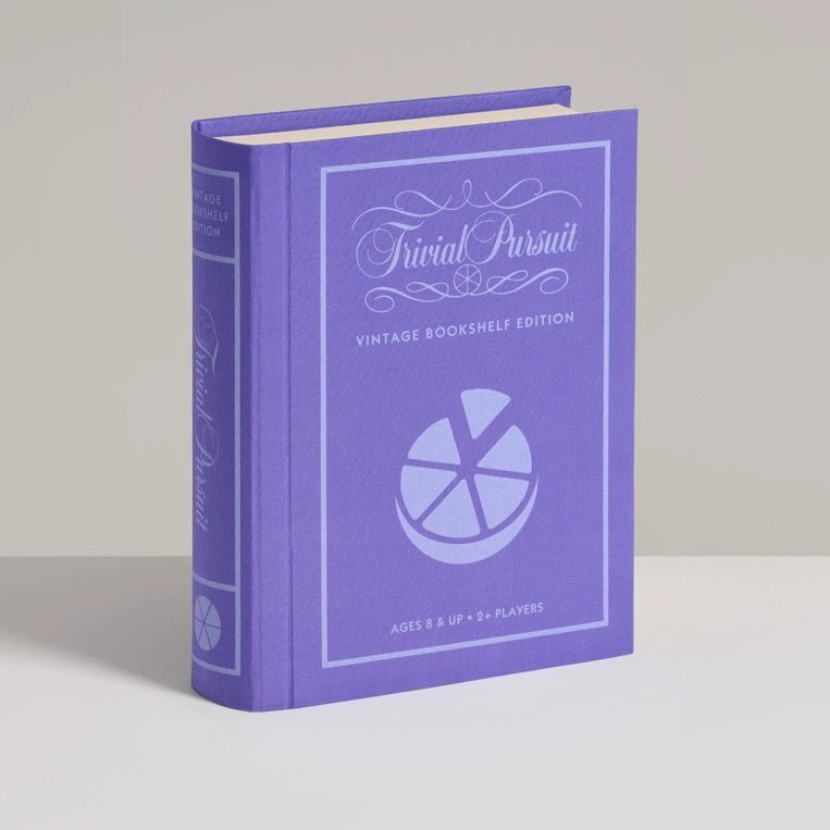 Vintage Bookshelf Edition of Trivial Pursuit by WS Game Company, featuring game pieces and colorful trivia question cards on a bookshelf.